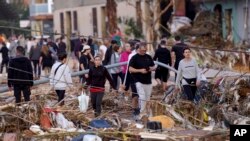 Los residentes caminan por una calle después de las inundaciones en Paiporta, cerca de Valencia, España, el miércoles 30 de octubre de 2024. (Foto AP/Alberto Saíz).