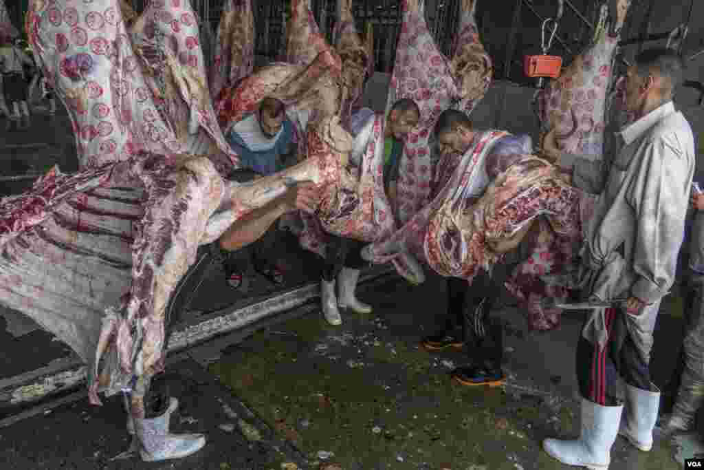 Workers carry meat marked "approved for human consumption" by government inspectors, in Cairo, July 17, 2021.