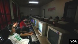 Anak-anak muda di Tiongkok sedang menggunakan komputer di sebuah kafe internet Beijing, Tiongkok.