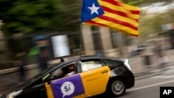 A man drives his taxi decorated with an estela flag and publicity supporting the Oct. 1 vote in Barcelona, Spain Friday, Sept. 22, 2017.