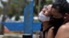 Kelvia, 16 ans, et sa tante, en pleurs lors de l'enterrement de sa mère Andrea dos Reis Brasao, décédée à 39 ans des suites de la maladie à coronavirus, Manaus, Brésil, 17 janvier 2021. (Reuters/Bruno Kelly)