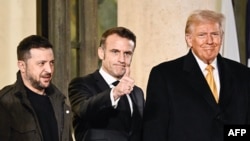Francuski predsjednik Emmanuel Macron diže palac dok ga prate ukrajinski predsjednik Volodymyr Zelenskyy i novoizabrani predsjednik SAD Donald Trump nakon sastanka u Jelisejskoj predsjedničkoj palati u Parizu 7. decembra 2024. godine.