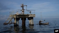 Una embarcación navega cerca de un pozo petrolero del Lago de Maracaibo, en Venezuela, en octubre de 2022. Este martes, se supo que una refinería india presentó una nueva solicitud a Estados Unidos para trabajar en Venezuela.