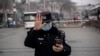 FILE - A police officer gestures during the opening session of the National Peoples Congress in Beijing, March 5, 2021.