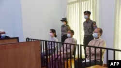 Aung San Suu Kyi (kiri) dan Win Myint (tengah) ketika hadir dalam pengadilan pertama mereka di Naypyidaw, Myanmar. (Foto: AFP)