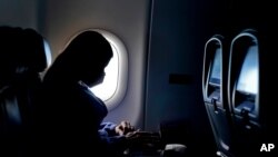 FILE - A passenger wears a face mask during a flight after taking off from Atlanta, Feb. 3, 2021.