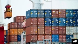 FILE - A container is loaded onto a cargo ship at the Tianjin port in China. The U.S. trade deficit with China grew 2.3 percent in January to $21.9 billion.