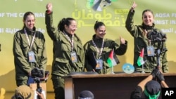 Las rehenes israelíes Naama Levy, Daniella Gilboa, Karina Ariev y Liri Albag, sin ningún orden en particular, saludan a una multitud palestina antes de ser entregadas a la Cruz Roja en la ciudad de Gaza, el sábado 25 de enero de 2025. [Foto: AP/Abed Hajjar]