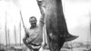 Ernest Hemingway posando con un marlin en el Havana Harbor, Florida, en julio de 1934. (Foto John F. Kennedy Presidential Library and Museum, Boston vía AP)