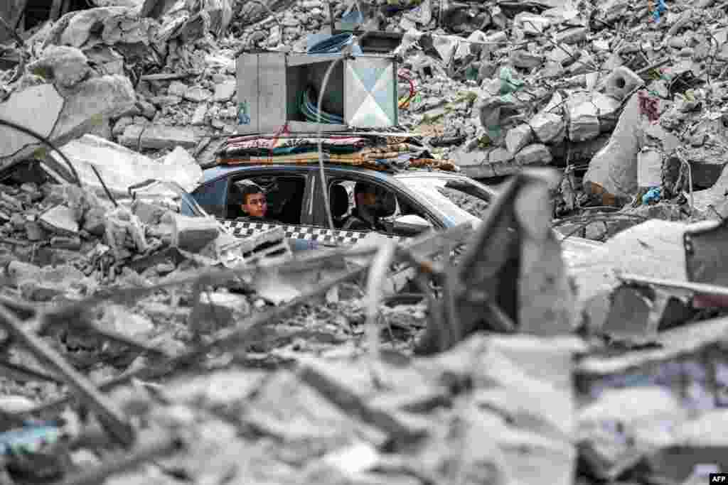 A vehicle moves past the rubble of collapsed buildings in Khan Yunis in the southern Gaza Strip, amid the ongoing war in the Palestinian territory between Israel and Hamas.