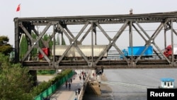 Antrian truk menunggu pemeriksaan perbatasan di ujung Jembatan Persahabatan (Friendship Bridge) yang menghubungkan Sinuiju, Korea Utara, dengan Dandong, provinsi Liaoning, China, di atas Sungai Yalu, 24 Mei 2018. (Foto: dok).