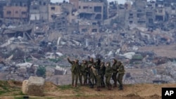 Soldados israelíes posan para una selfie en la frontera de la Franja de Gaza, en el sur de Israel, el lunes 19 de febrero de 2024. (AP Photo/Tsafrir Abayov).