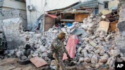 Seorang tentara Somalia berjalan melintas di depan Hotel Afrik usai serangan pemberontak di Mogadishu, Somalia, 1 Februari 2021. (Foto: AP)