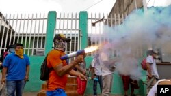 Seorang pengunjuk rasa dengan mengenakan masker menembakan mortir buatannya di kawasan Monimbo dalam bentrokan dengan polisi di Masaya, Nikaragua, 2 Juni 2018. Sedikitnya 152 orang tewas dalam bentrokan antara pasukan yang setia kepada Presiden Daniel Ortega dan kelompok oposisi.
