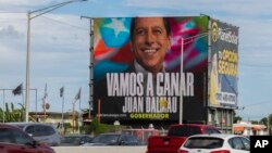 Una valla publicitaria que promueve al Partido Independentista de Puerto Rico y al candidato a gobernador del Movimiento de Victoria Ciudadana, Juan Dalmau, se eleva sobre una carretera, en San Juan, Puerto Rico, el 2 de noviembre de 2024.