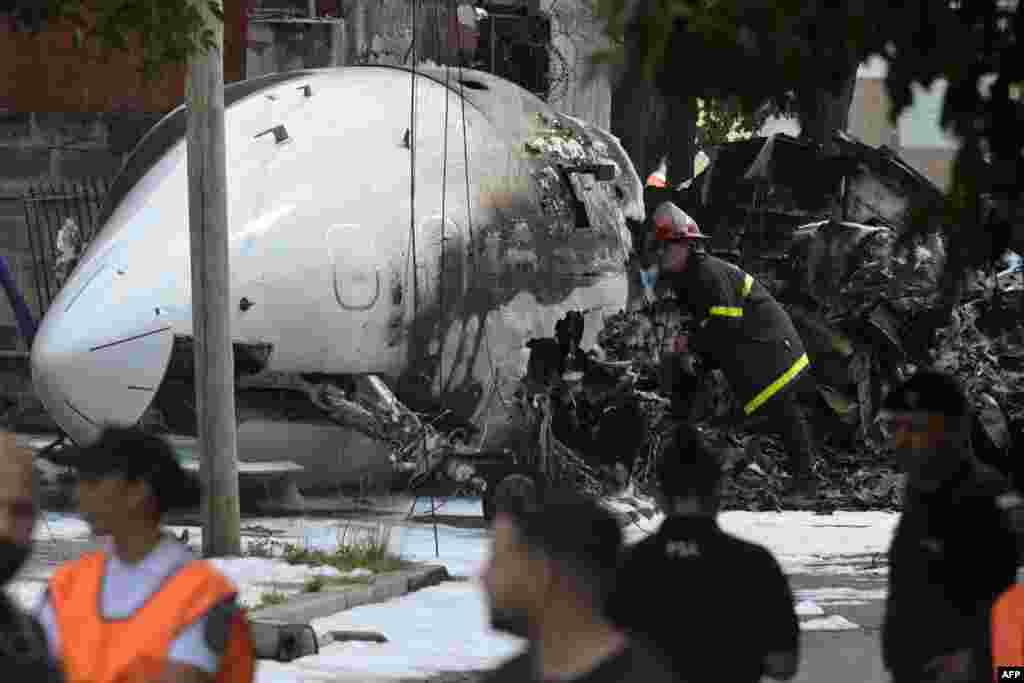 A firefighter inspects the wreckage of a Challenger 300 aircraft that crashed upon landing in the town of San Fernando, Buenos Aires Province, Argentina. The pilot and co-pilot died after the private plane crashed and caught fire near the airport of San Fernando. No other injuries were reported.