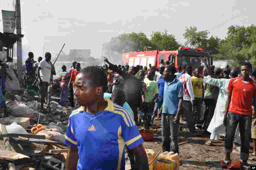 People gather at the scene of a car bomb explosion, at the central market, in Maiduguri, Nigeria, July 1, 2014.