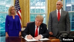 Shugaban Amurka Donald Trump yayinda yake rabtawa dokar soke raba yara da iyayensu