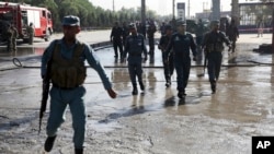 FILE - Afghan police soldiers inspect the site of a suicide attack in Kabul, Afghanistan, Monday, June 20, 2016.