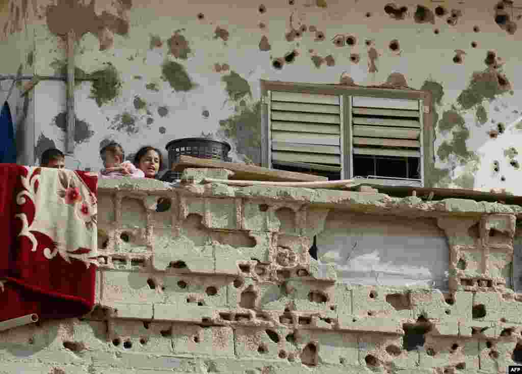 Anak-anak Palestina berdiri di balkon rumah keluarga mereka yang rusak akibat operasi militer Israel di kota Rafah, Jalur Gaza selatan.