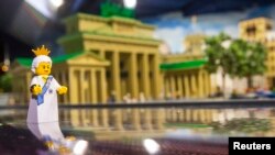 FILE - A Lego figure representing Britain's Queen Elizabeth II is placed in front of the Brandenburg Gate made of Lego bricks, in Legoland in Berlin, Germany, June 18, 2015. Lego has unveiled a new model in honor of the May 19 royal wedding of Prince Harry and Meghan Markle. 
