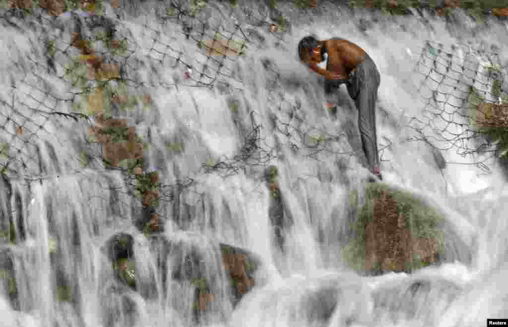 Seorang anak laki-laki mandi di aliran sungai Dara, di pinggiran kota Srinagar, Kashmir-India.