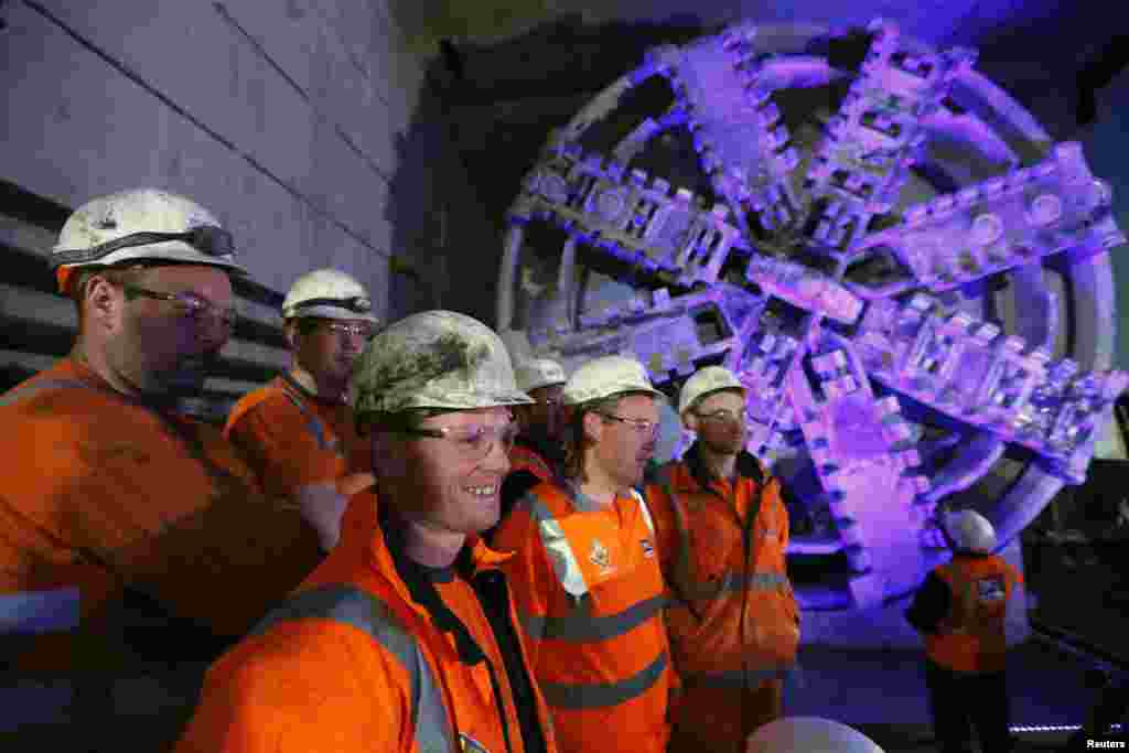 Para pekerja terowongan berdiri di samping mesin pembuka terowongan 'Elizabeth' ketika diumumkannya secara resmi bahwa mereka telah mencapai Stasiun Crossrail di Canary Wharf, di London Timur. Proyek Crossrail ini yang akan menghubungkan London Timur dan Barat, sepertiganya lengkap dan dijadualkan akan selesai tahun 2018.