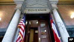 The Mississippi state flag anchored across from the American flag, outside the Governor's Office at the Capitol in Jackson, Miss., June 29, 2020, the day after both chambers of the state Legislature passed a bill to take down and replace the current flag.