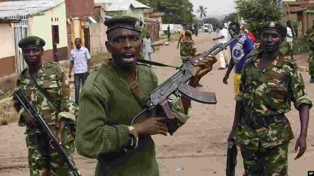Des soldats tirent en l'air pour disperser des manifestants qui ont acculé Jean Claude Niyonzima, un membre présumé de la milice Imbonerakure de la jeunesse du parti au pouvoir dans un égout dans le quartier de Cibitoke de Bujumbura, au Burundi, jeudi 7 mai 2015.