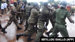 La police guinéenne arrête un manifestant devant le plus grand stade de Conakry lors d'une manifestation interdite, le 28 septembre 2009.