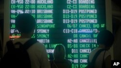 Passengers looks at an information board at Bali's international airport, Indonesia, June 28, 2018.