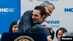 New York Mayor Bill de Blasio hugs Dr. Craig Spencer as he is discharged from Bellevue Hospital, after being stricken by Ebola, in New York Nov. 11, 2014.