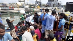 Foto yang dirilis tanggal 17 Oktober 2012 ini memperlihatkan para pencari suaka dari Sri Lanka tengah berupaya keluar dari kapal nelayan yang mereka tumpangi setelah tertangkap di sekata pangkalan angkatan laut di Galle, Sri Lanka. (AP Photo/Sajeewa Wijeweera). Sebuah kapal yang mengangkut 22 pencari suaka asal Sri Lanka, dilaporkan terdampar di dekat pulau Nusakambangan, Selasa (29/1).