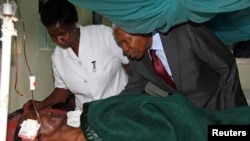 Tanzania's Vice President Mohamed Gharib Bilal consoles a faithful at Mount Meru Hospital, who was injured during an explosion at the new Catholic church, in the northern Tanzanian town of Arusha, May 6, 2013.