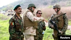 FILE - Afghan national army officers discuss lessons learned alongside Marines and Navy personnel while participating in combat scenario training exercises at U.S. Marine Corps Base Camp Pendleton in California, Jan. 14, 2010. 