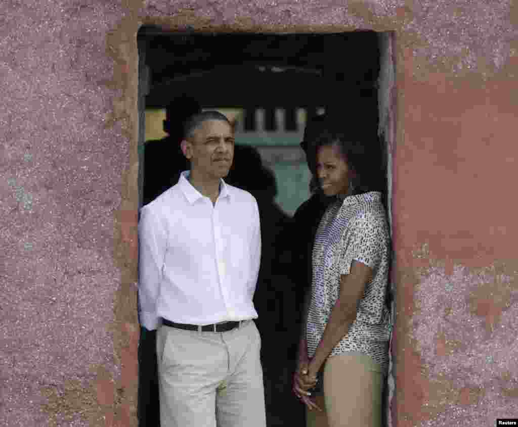 U.S. President Barack Obama and first lady Michelle Obama look out of a doorway that slaves departed from on Goree Island, Senegal, June 27, 2013.