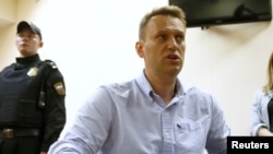 Pemimpin oposisi Rusia, Alexei Navalny, berbicara kepada para wartawan selama sidang dengar di pengadilan di Moskow, Rusia (foto: Sergei Karpukhin/REUTERS)