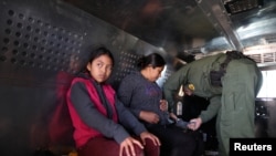 FILE - Migrants from Guatemala, sit in a truck after surrendering to U.S. Border Patrol Agents in El Paso, Texas, March 5, 2019. U.S. Border Patrol intercepted a similar truck with 32 migrants in Arizona this week.