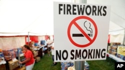 A no smoking sign is seen in an Iowa Fireworks Company tent, in Adel, Iowa. Decades after a devastating fire caused by a dropped sparkler led Iowa to ban fireworks, the explosives are now legal in the state, June 15, 2017. 