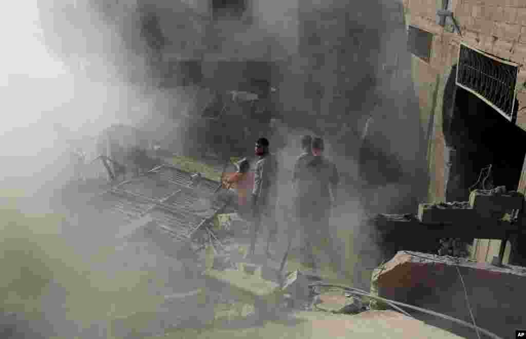 Palestinians inspect the rubble of a house after it was hit by an Israeli missile strike in Gaza City, July 10, 2014.
