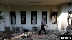 A policeman walks past a damaged window after riots following the announcement of last month's presidential election results at the Election Supervisory Agency (Bawaslu) headquarters in Jakarta, Indonesia, May 23, 2019. 