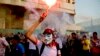 An anti-coup protester wearing a Guy Fawkes mask hold a flare during a demonstration in Cairo, Oct. 6, 2013. (H. Elrasam for VOA)