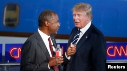 FILE - Republican U.S. presidential candidates Dr. Ben Carson, left, and businessman Donald Trump top a new poll. They're shown chatting at a candidates debate, Sept. 16, 2015. 