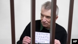 Критик Кремля Олексій Горінов в суді 29 листопада 2024 року тримає напис: "Досить вбивати. Зупини війну".