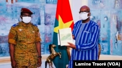 Roch Kaboré recevant le rapport d’enquête sur le drame d’Inata, à Ouagadougou, le 6 décembre 2021. (VOA/Lamine Traoré)