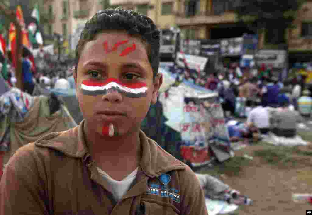 A young protester in Tahrir Square, his face painted with the word "Morsi."