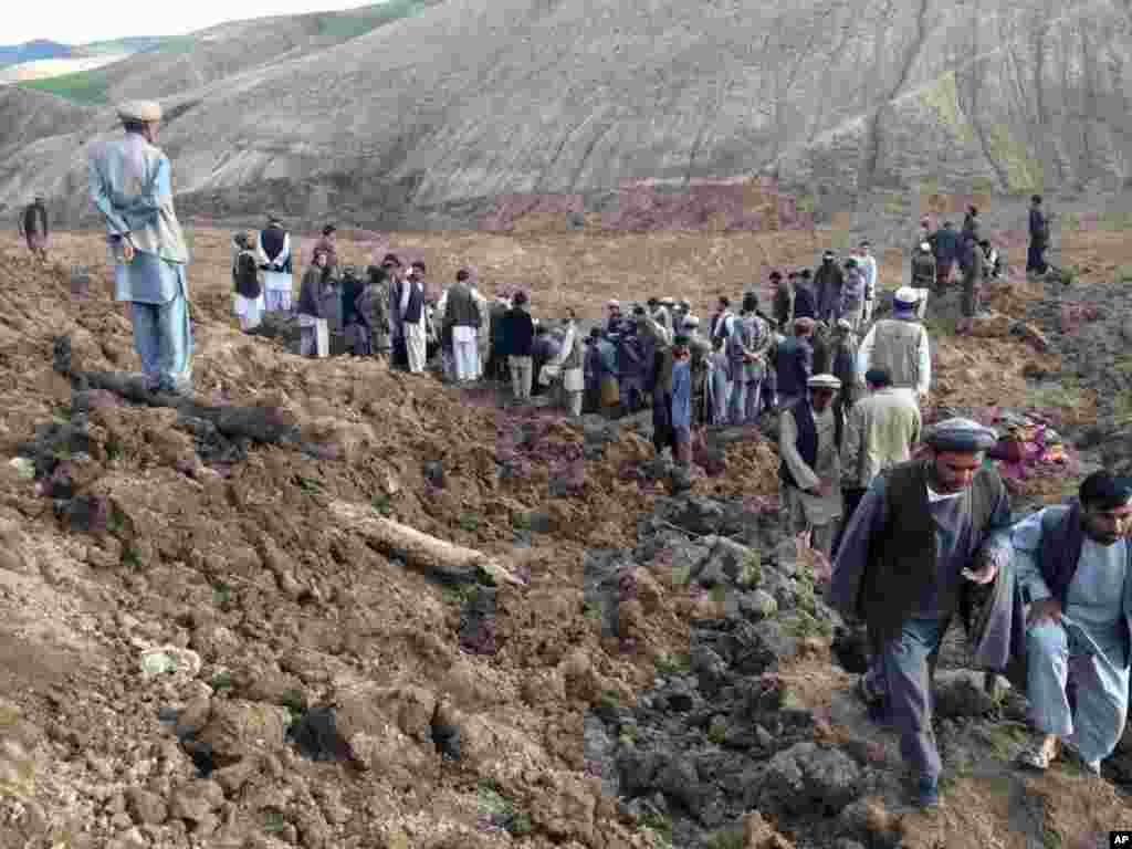 Warga mencari penyintas menyusul tanah longsor masif yang menimbun desa Abi-Barik di provinsi Badakhshan, timur laut Afghanistan (2/5). (AP/Ahmad Zubair)
