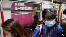 Commuters wear protection masks inside a subway train in Hong Kong, Jan. 7, 2020, thanks to a mysterious respiratory illness whose cause is unknown. 