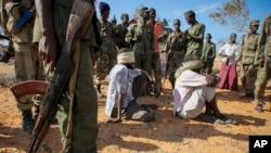Foto yang dirilis oleh tim pendukung pasukan gabungan Uni Afrika dan PBB ini memperlihatkan tersangka anggota al-Shabab yang ditutup matanya dan dikawal ketat di sebuah kantor polisi oleh tentara Somalia (SNA) di Kismayo, selatan Somalia (3/10). Militan Somalia al-Shabab mengatakan bahwa Pasukan Militer Barat telah melancarkan serangan di selatan kota Mogadishu, Sabtu (5/10).