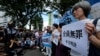 Activists hold placards during a rally in front of the Tokyo District Court in Tokyo, Sept. 19, 2019, after the court acquitted three former officials from the firm that operated the Fukushima nuclear plant.